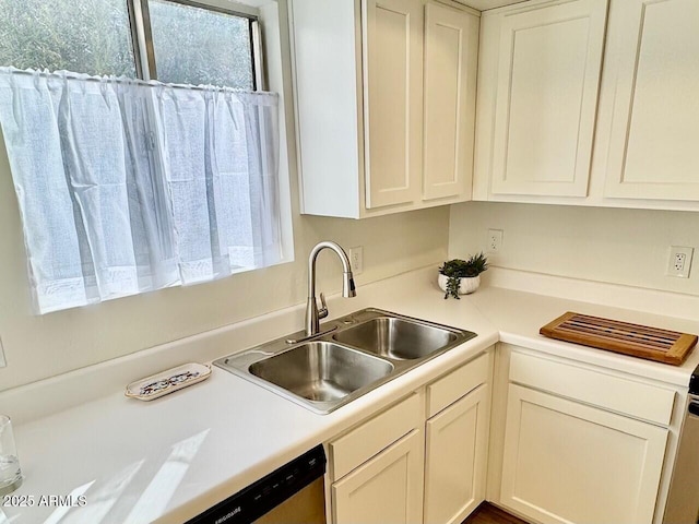 kitchen featuring sink, white cabinets, and dishwasher