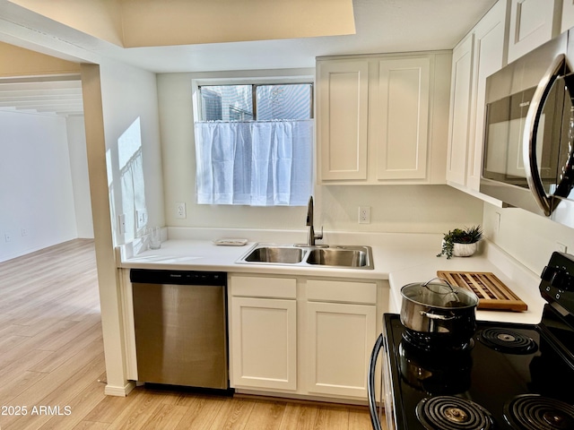 kitchen featuring sink, white cabinets, light hardwood / wood-style flooring, and stainless steel appliances