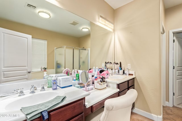 full bathroom featuring vanity, baseboards, visible vents, a shower stall, and tile patterned floors