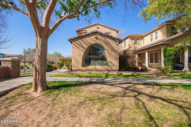 view of front of property featuring a front lawn and stucco siding