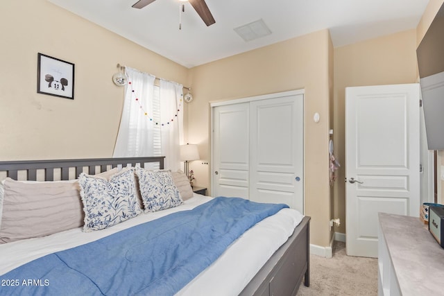 bedroom featuring visible vents, light carpet, a closet, baseboards, and ceiling fan