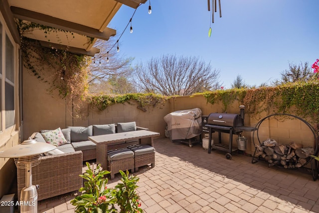 view of patio featuring an outdoor living space, a grill, and a fenced backyard