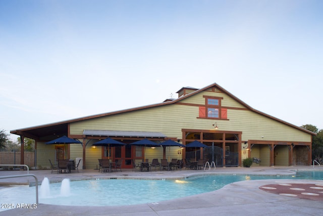 community pool with fence and a patio area