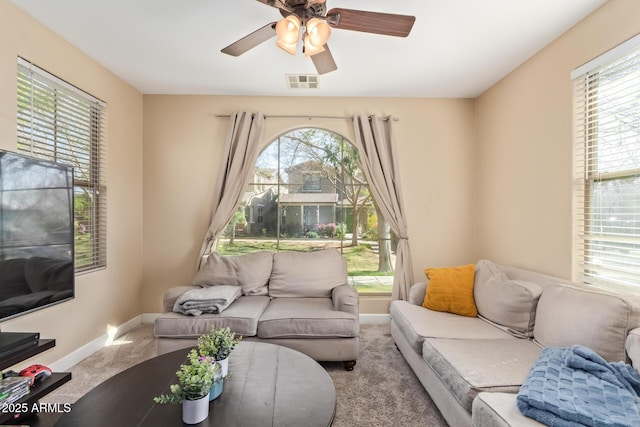 living room featuring a healthy amount of sunlight, visible vents, and carpet floors