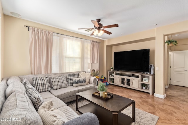 living area featuring baseboards, light tile patterned flooring, and a ceiling fan