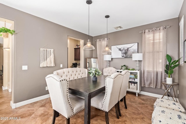 dining space featuring light tile patterned floors, visible vents, and baseboards