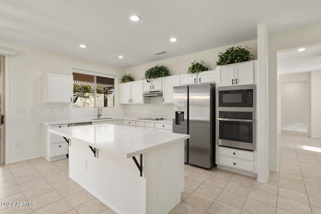 kitchen with white cabinetry, stainless steel appliances, and a kitchen island