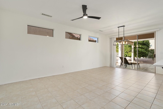 unfurnished room with light tile patterned floors and ceiling fan with notable chandelier