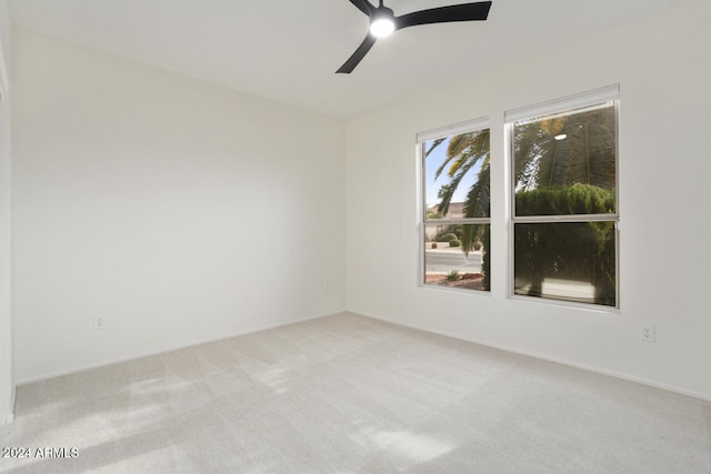 unfurnished room with light colored carpet and ceiling fan