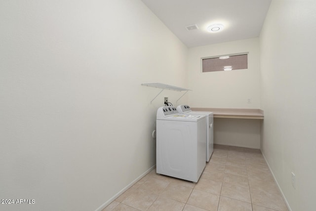 laundry area featuring light tile patterned flooring and washer and clothes dryer