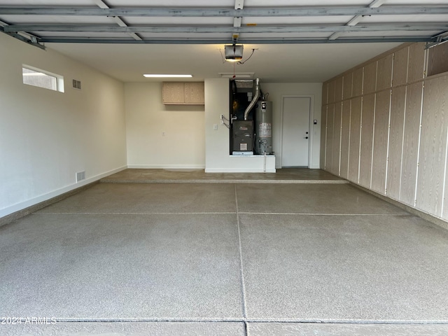 garage featuring water heater, heating unit, and a garage door opener