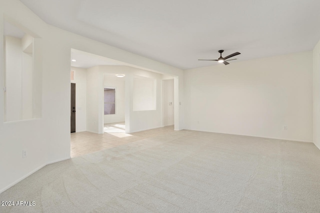 spare room featuring light colored carpet and ceiling fan