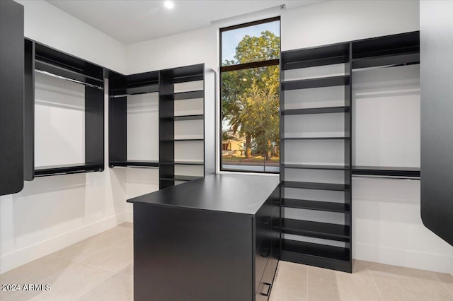 walk in closet with light tile floors