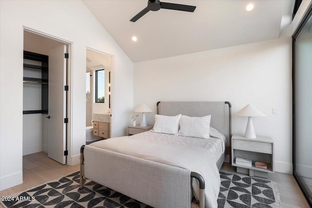 bedroom featuring ensuite bathroom, vaulted ceiling, ceiling fan, hardwood / wood-style flooring, and a closet