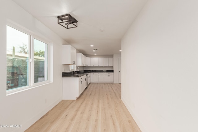 kitchen featuring white cabinetry, sink, and light hardwood / wood-style flooring