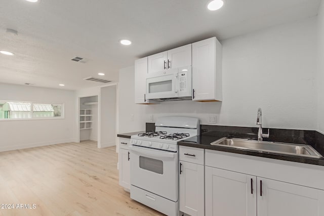 kitchen with white cabinetry, sink, white appliances, and light wood-type flooring