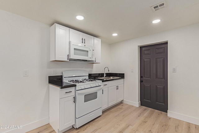 kitchen with white cabinets, white appliances, light hardwood / wood-style floors, and sink