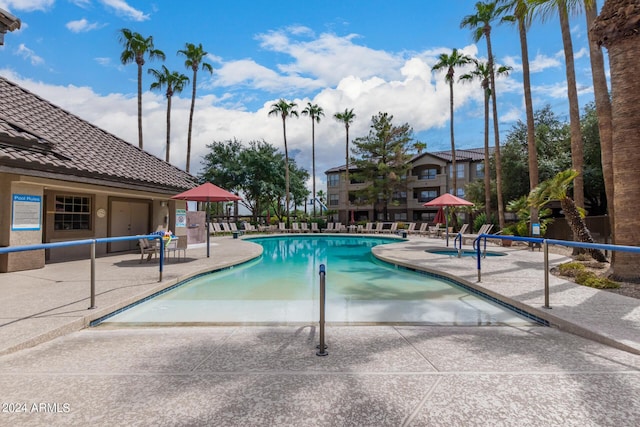 pool with a patio area and fence