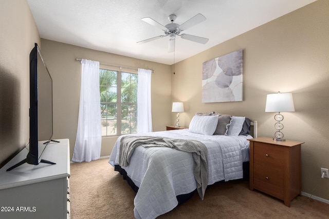 bedroom featuring a ceiling fan, light carpet, and baseboards