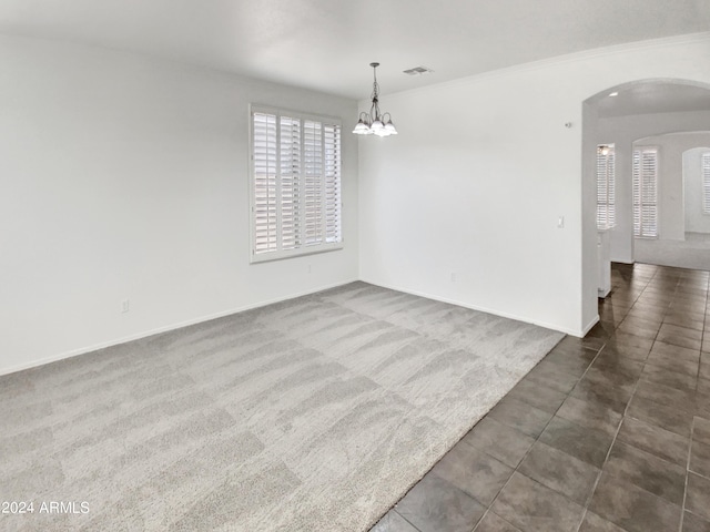 empty room featuring a notable chandelier, visible vents, arched walkways, and dark colored carpet