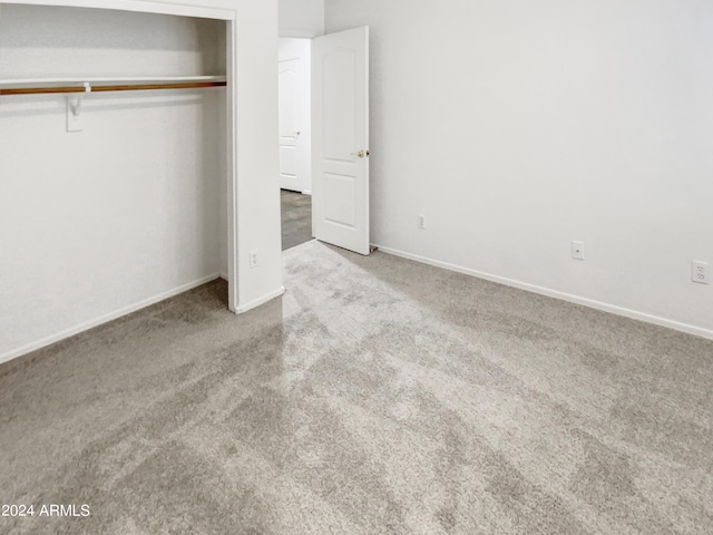 unfurnished bedroom featuring a closet, baseboards, and carpet