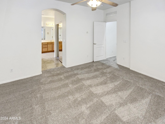 interior space with baseboards, visible vents, arched walkways, and light carpet