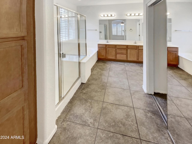 bathroom featuring a bath, a shower stall, and tile patterned flooring