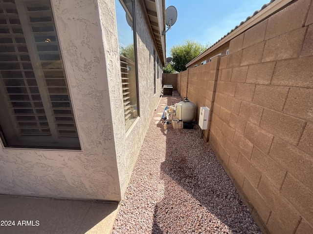 view of home's exterior featuring stucco siding, cooling unit, and fence