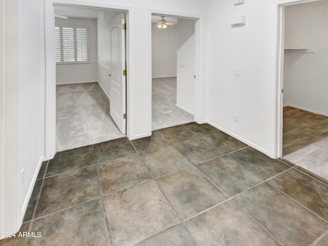 interior space featuring baseboards, a ceiling fan, and carpet floors