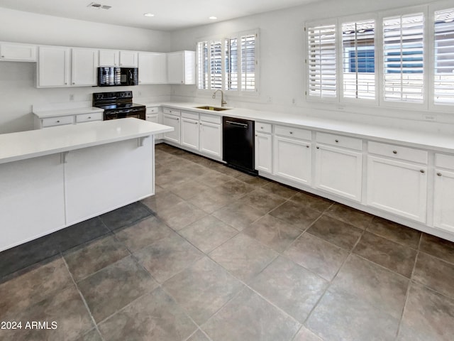 kitchen with visible vents, black appliances, a sink, white cabinets, and light countertops