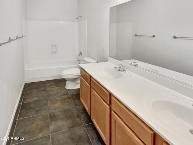 bathroom featuring double vanity, toilet, and a sink