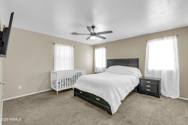 bedroom with a ceiling fan, light colored carpet, and baseboards