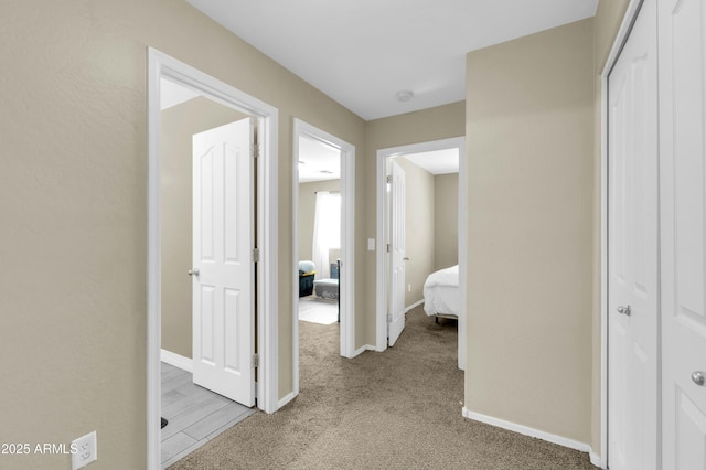 corridor with light carpet and baseboards