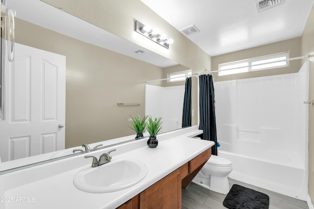 full bathroom featuring visible vents, shower / tub combo with curtain, vanity, and toilet