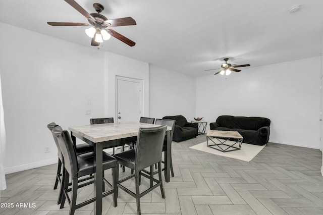 dining room featuring ceiling fan and baseboards