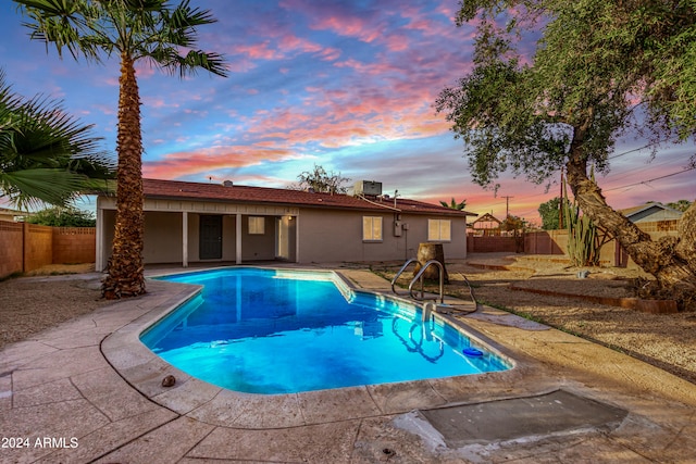 pool at dusk featuring a patio area