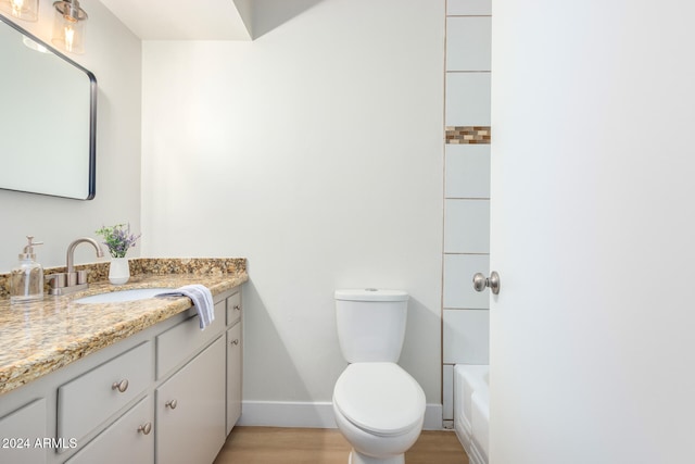 bathroom with hardwood / wood-style floors, vanity, and toilet