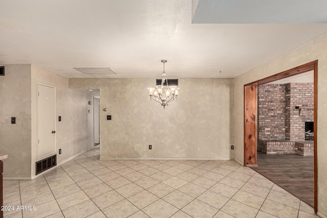 empty room with a chandelier and light hardwood / wood-style floors