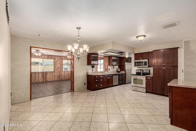 kitchen with pendant lighting, ceiling fan with notable chandelier, stainless steel appliances, and a healthy amount of sunlight