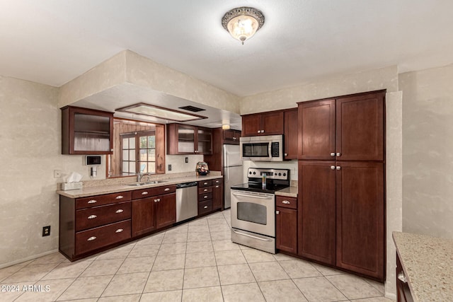 kitchen featuring light stone countertops, sink, french doors, stainless steel appliances, and light tile patterned floors