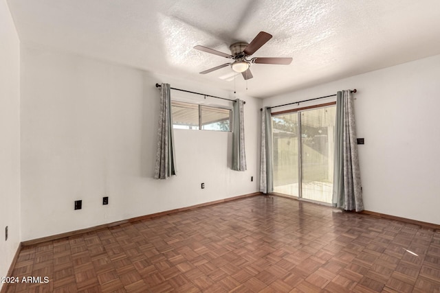 spare room featuring ceiling fan, a textured ceiling, and dark parquet floors