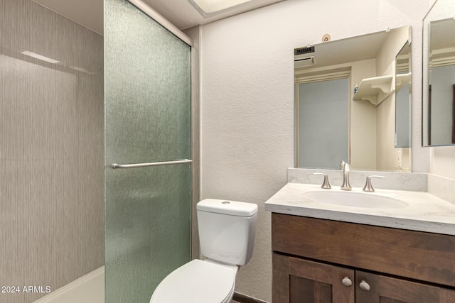 bathroom featuring vanity, toilet, and an enclosed shower