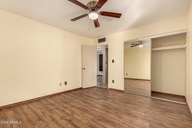 unfurnished bedroom with ceiling fan, a closet, and hardwood / wood-style flooring