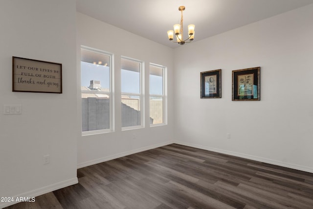 unfurnished room with dark wood-type flooring and an inviting chandelier