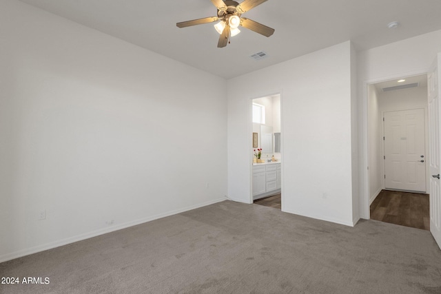 unfurnished bedroom with ensuite bath, ceiling fan, and carpet floors