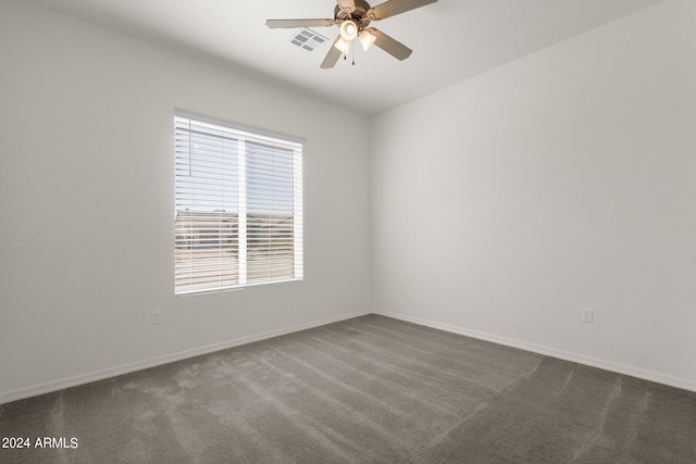 unfurnished room with dark carpet and ceiling fan