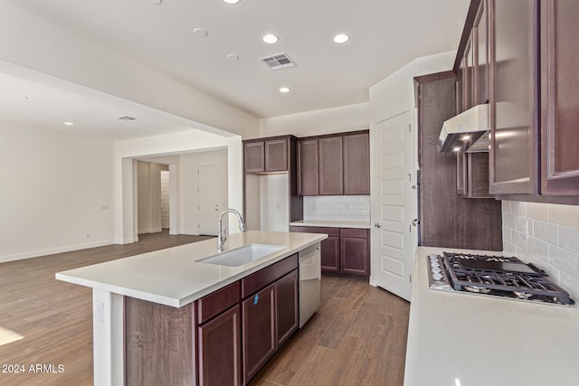 kitchen with dark wood-type flooring, sink, an island with sink, stainless steel appliances, and extractor fan