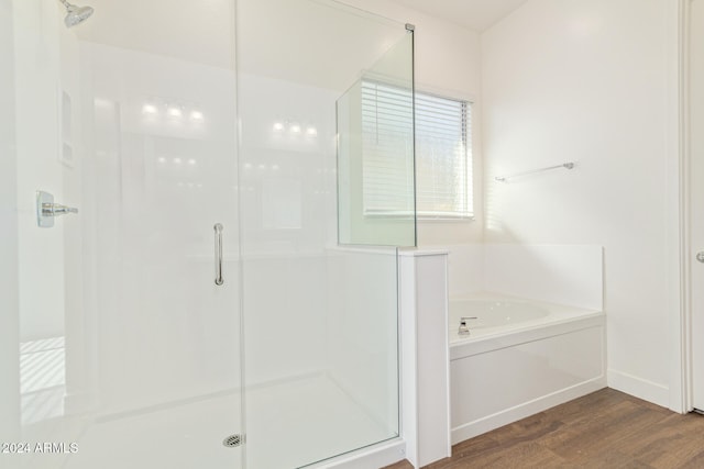 bathroom featuring hardwood / wood-style flooring and shower with separate bathtub