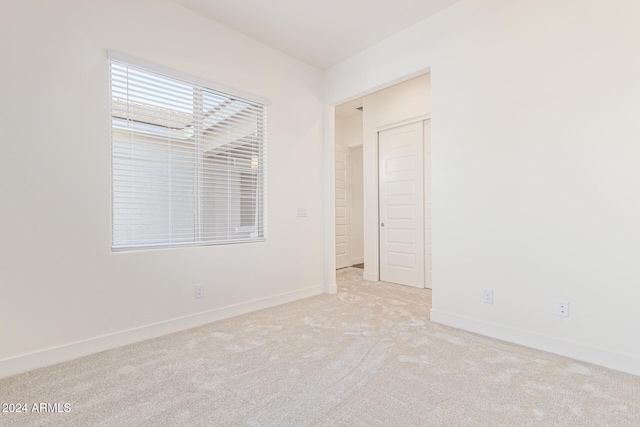 spare room featuring light carpet