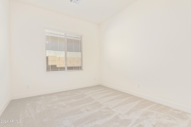 empty room with light colored carpet and lofted ceiling